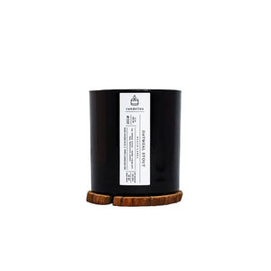 Soy Candle in Oatmeal Stout scent in a sleek black tumbler featuring a minimalist white label and displayed on a wooden coaster