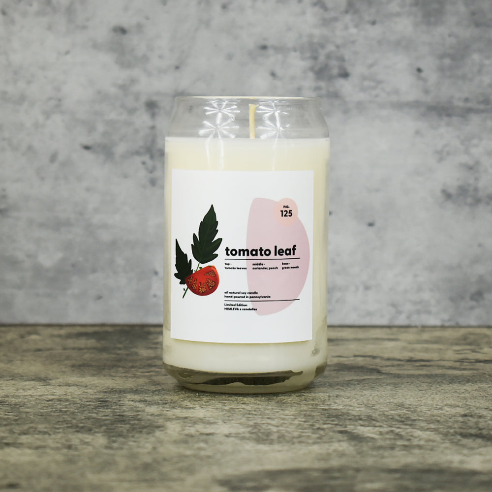 Tomato Leaf scent soy wax candle in can shaped glass vessel with tapered top and beautifully minimal label with pastel shapes and a mint leaf drawing from our Hemleva Collaboration