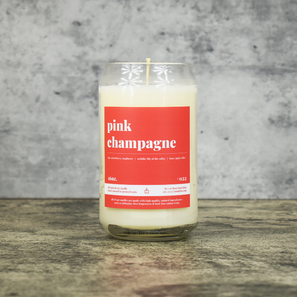 Pink Champagnescent soy wax candle in can shaped glass vessel with tapered top and bright pink label