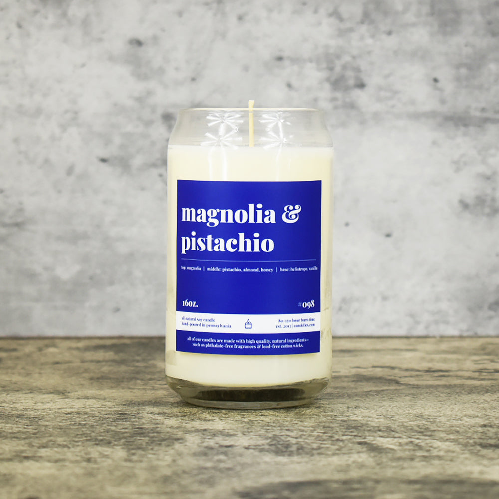 Magnolia and Pistachio scent soy wax candle in can shaped glass vessel with tapered top and deep blue label